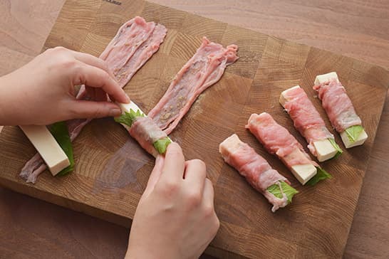 豚肉をまな板の上に広げて、こしょうを振ります。肉の端に青じそ、高野豆腐の順において巻き、片栗粉をまぶします。